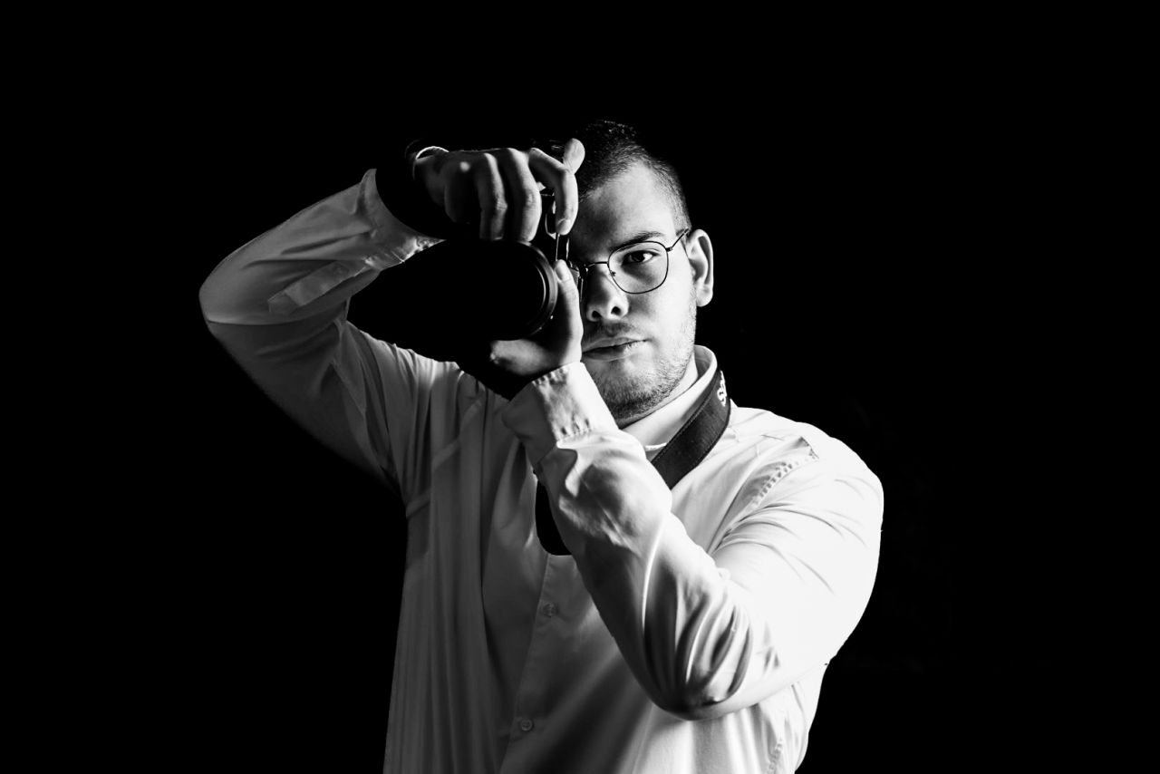 Yoan, photographe, tenant son appareil photo